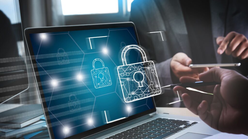 Cybersecurity concept showing digital padlocks on a laptop screen with professionals reviewing data on a mobile device. Visual representation of website security, compliance, and data protection for small business infrastructure.